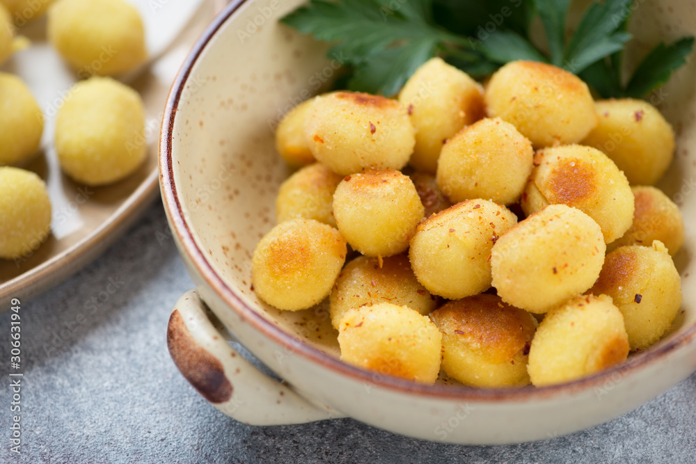 Close-up of pan fried stuffed potato gnocchi in a bowl, selective focus, studio shot