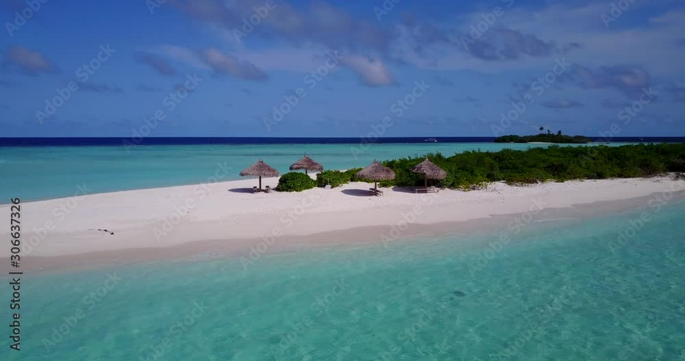 Beautiful tropical beach with straw umbrellas on white sand washed by turquoise lagoon with calm clear emerald water in Maldives Beautiful tropical beach with straw umbrellas on white sand washed by turquoise lagoon with calm clear emerald water in Maldives