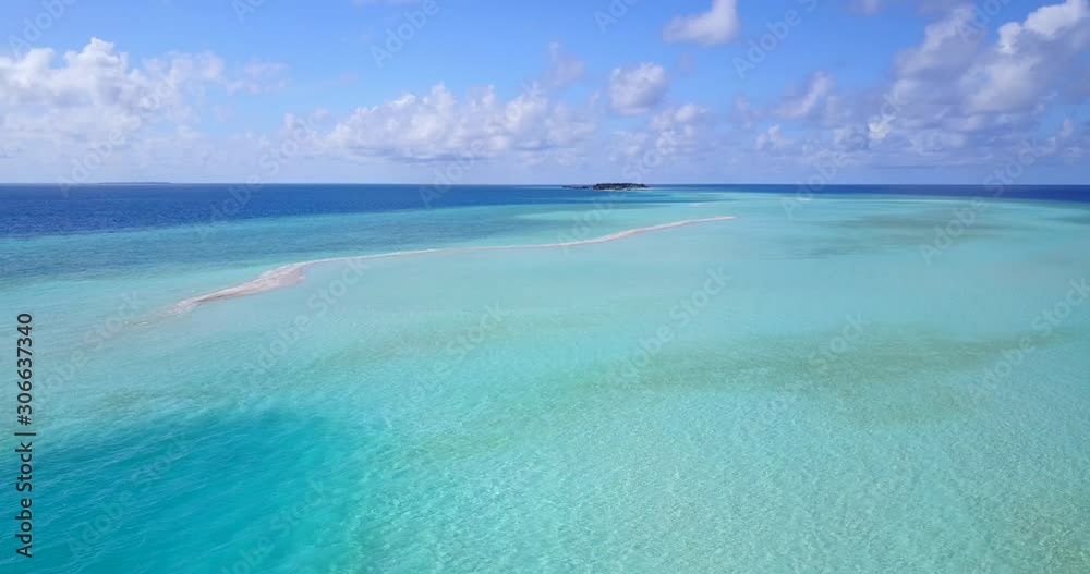Azure turquoise lagoon around atoll with large rocky barriers and small tropical islands surrounded by blue ocean on a bright sky with clouds in Maldives Azure turquoise lagoon around atoll with large rocky barriers and small tropical islands surrounded by blue ocean on a bright sky with clouds in Maldives