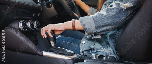 Closeup image a female driver shifting automatic gear stick while driving car