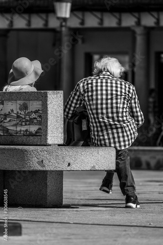 pareja sentados en banco de piedra en la plaza de zocodover en toledo photo