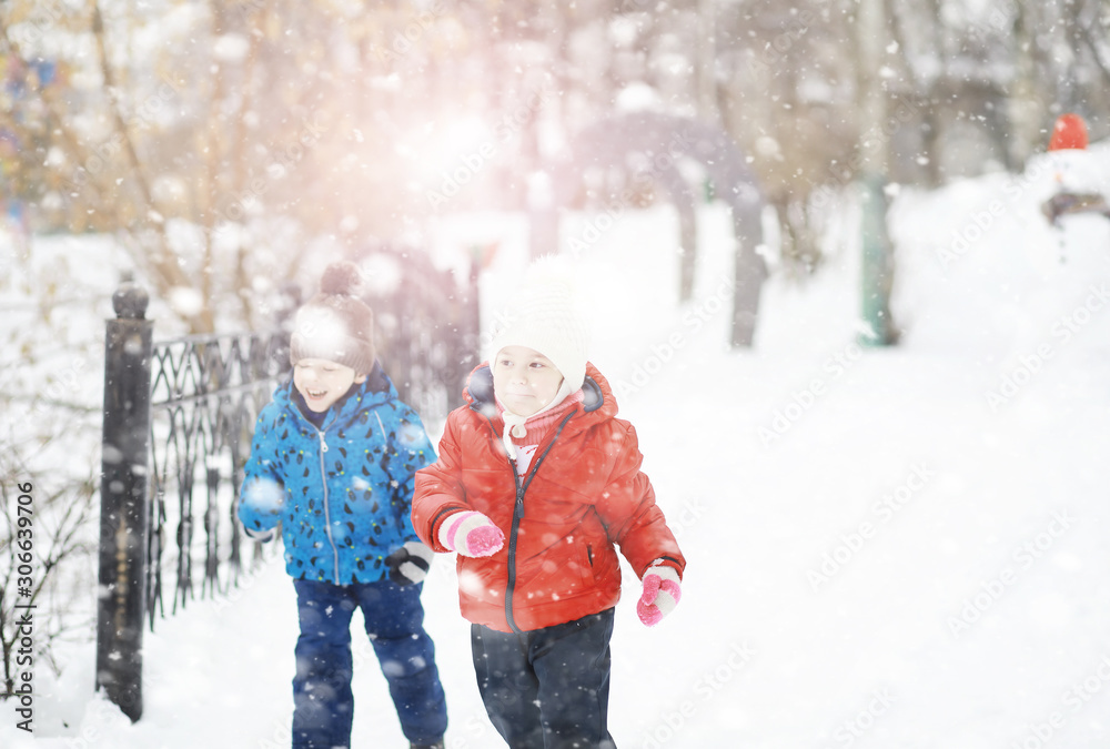 Children in the park in winter. Kids play with snow on the playground. They sculpt snowmen and slide down the hills. Children in the park in winter. Kids play with snow on the playground. They sculpt snowmen and slide down the hills.