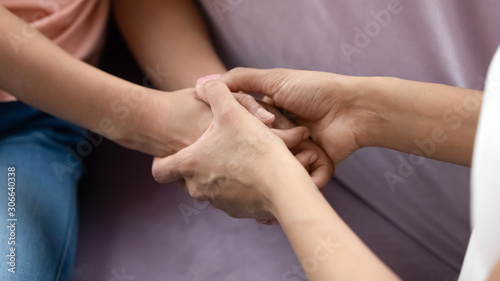 African American mom and daughter hold hands talking