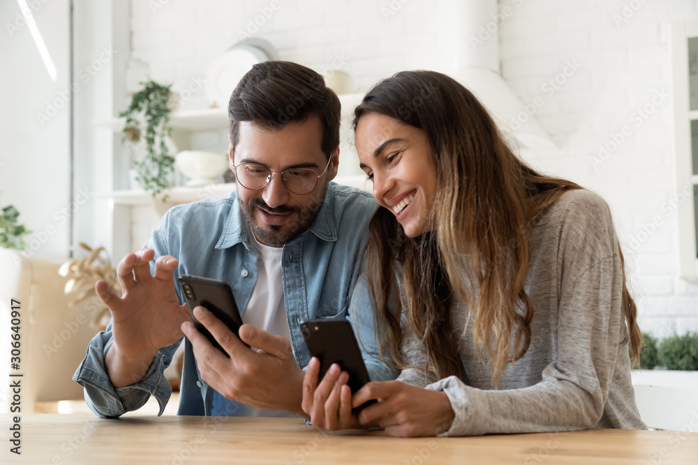 Young couple using smartphones share social media news at home Young couple using smartphones share social media news at home