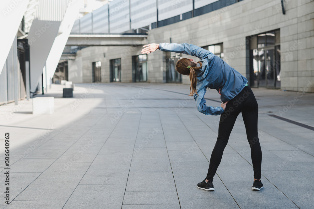Young adult athlete woman stretching body before cardio workout Young adult athlete woman stretching body before cardio workout