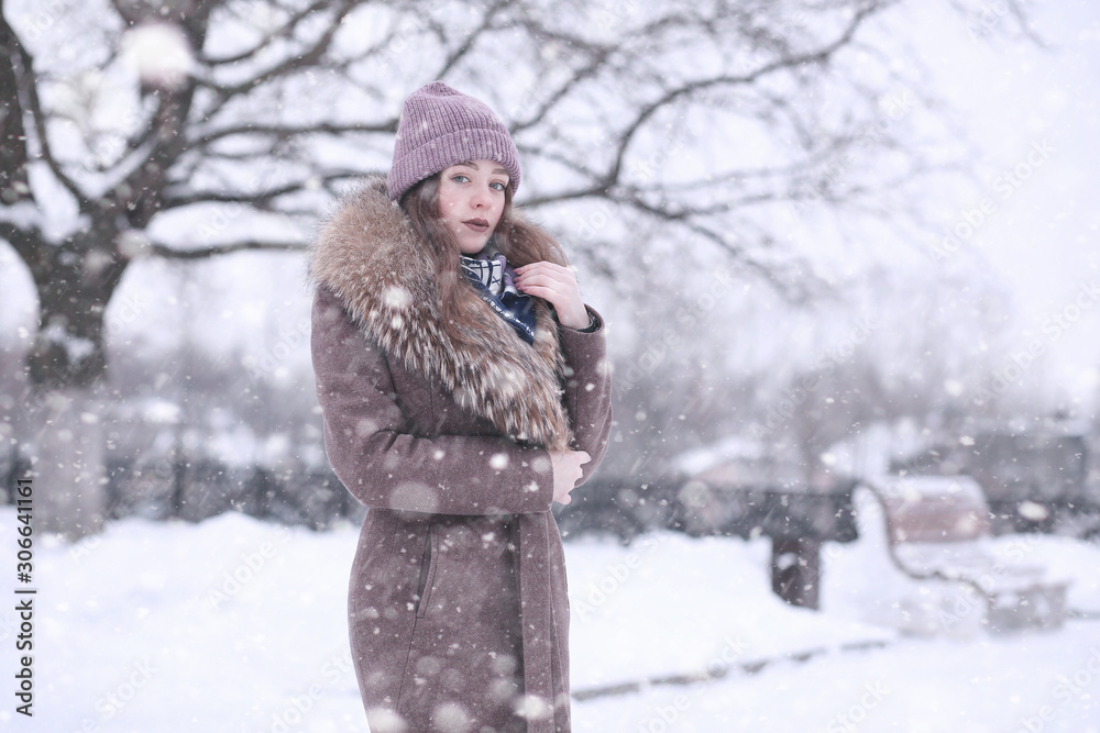 Girl in a winter park in snowfall Girl in a winter park in snowfall