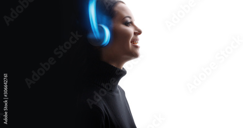 Happy beautiful woman in headphones listening music. White background. Blue neon light. Free space for text.