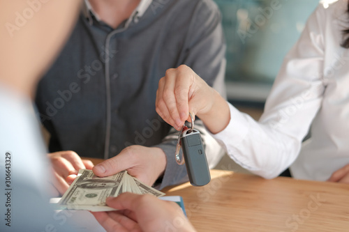 client pay for car. salesman dealer giving key to owner. car sale & dealership in auto business