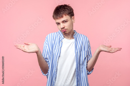 I don't know, sorry. Portrait of uncertain clueless brown-haired man with small beard and mustache raising hands, shrugging shoulders, no idea gesture. indoor studio shot isolated on pink background