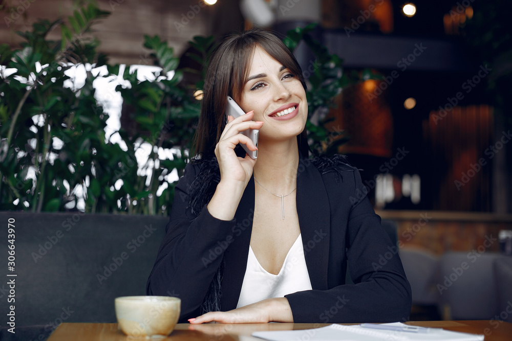 Woman working with a notebook. Lady with a coffee. Businesswoman use the phone Woman working with a notebook. Lady with a coffee. Businesswoman use the phone