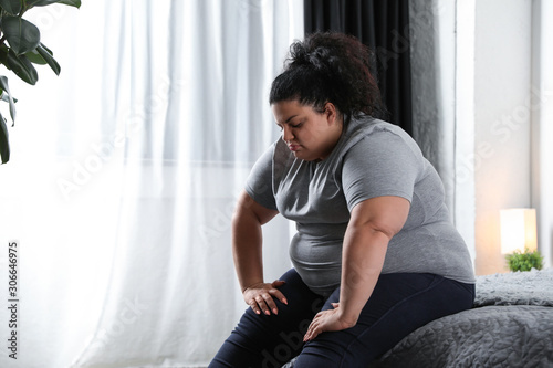 Фотография Depressed overweight woman on bed at home
