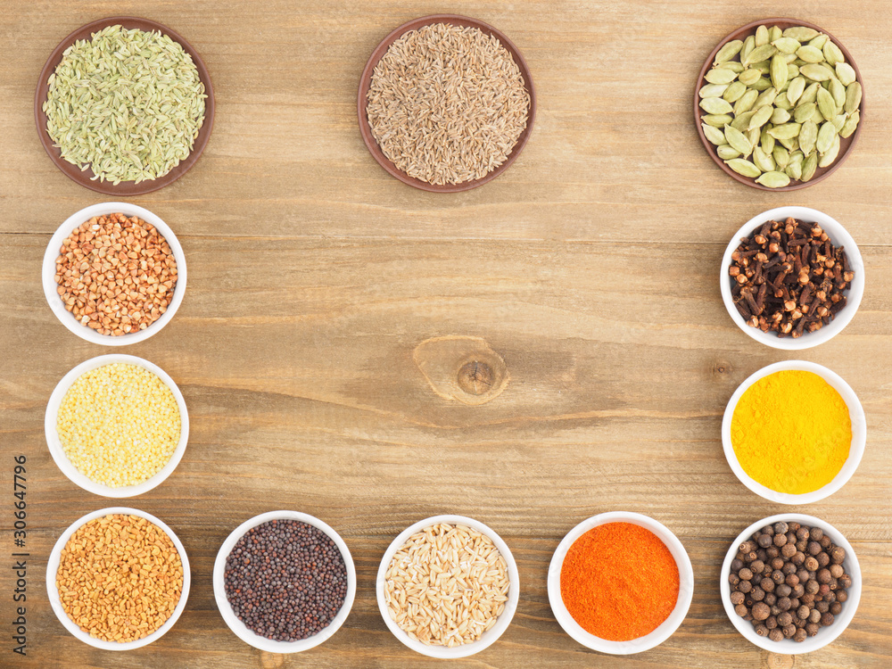 Buckwheat, oat, millet, green cardamom, allspice, cumin, pepper chili, fenugreek, turmeric, cloves, masala, mustard seeds on brown wooden background. Indian cuisine, ayurveda, naturopathy concept Buckwheat, oat, millet, green cardamom, allspice, cumin, pepper chili, fenugreek, turmeric, cloves, masala, mustard seeds on brown wooden background. Indian cuisine, ayurveda, naturopathy concept