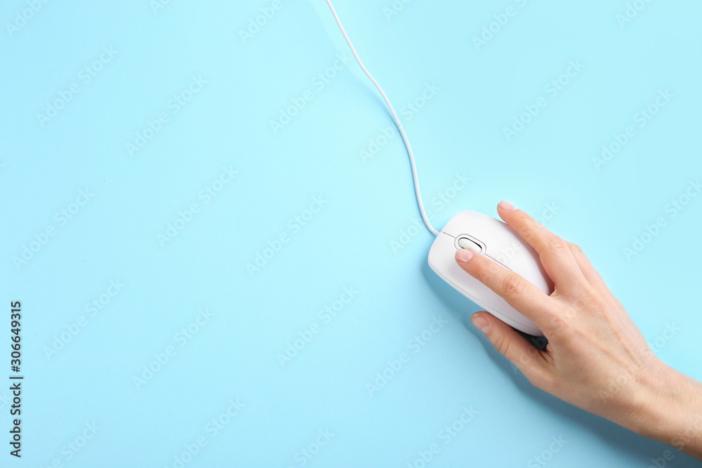 Woman using modern wired optical mouse on light blue background, top view. Space for text Woman using modern wired optical mouse on light blue background, top view. Space for text