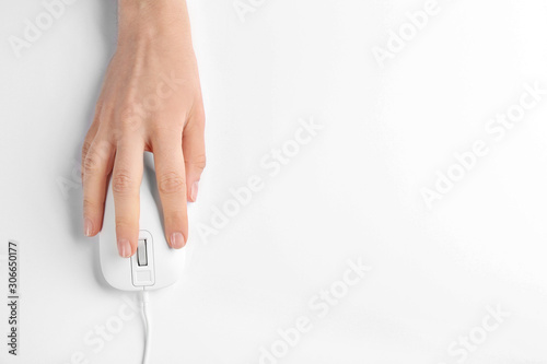 Woman using modern wired optical mouse on white background, top view