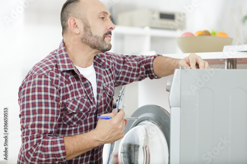 man with clipboard near washing machine