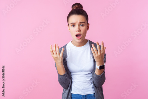 Billede på lærred What do you want? Portrait of disgruntled teenage girl with bun hairstyle in casual clothes looking annoyed irritated with raised hands, asking why