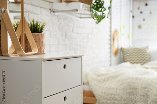 Stylish chest of drawers in bedroom interior