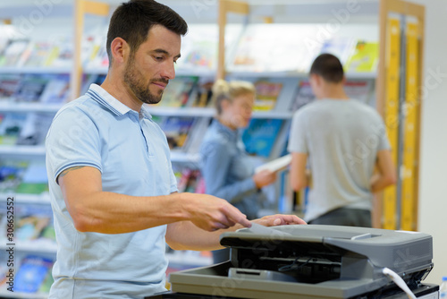 Fotografia a man using copier machine