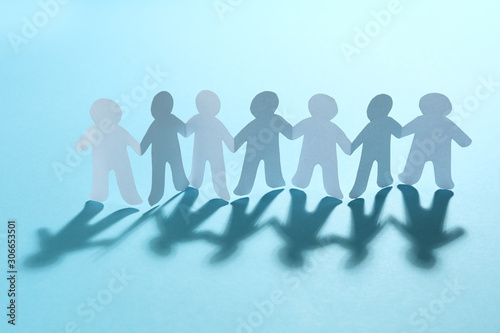 Paper people chain on light blue background. Unity concept
