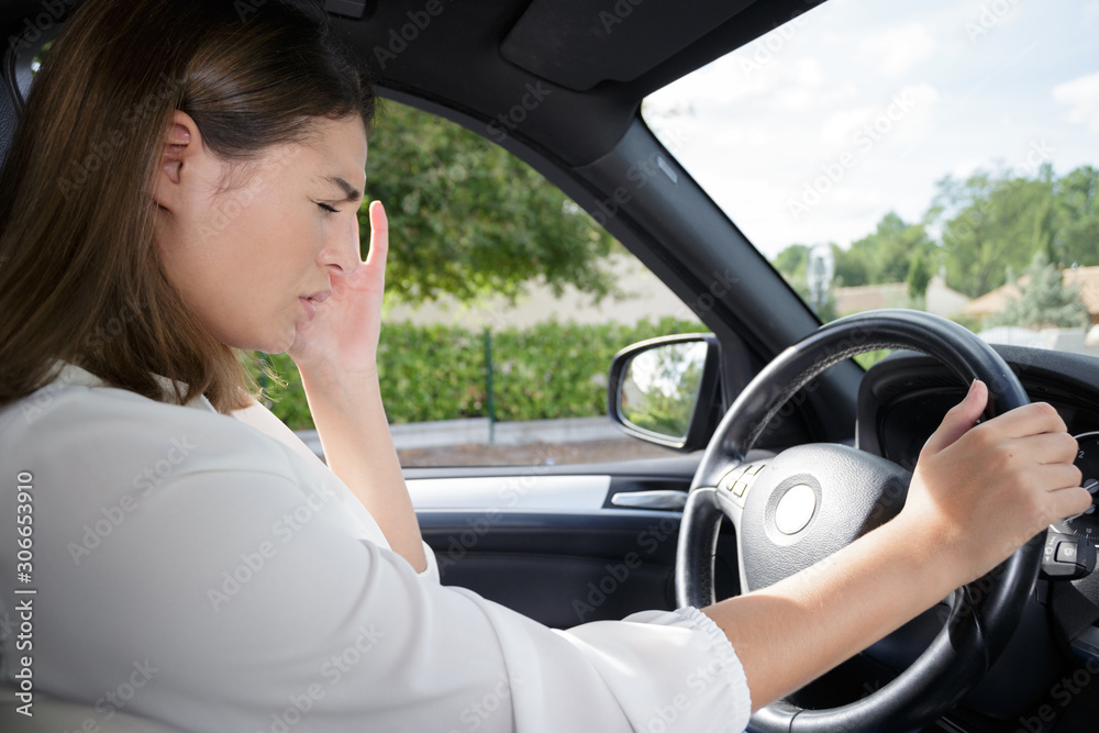 Naklejka premium woman having headache in a car