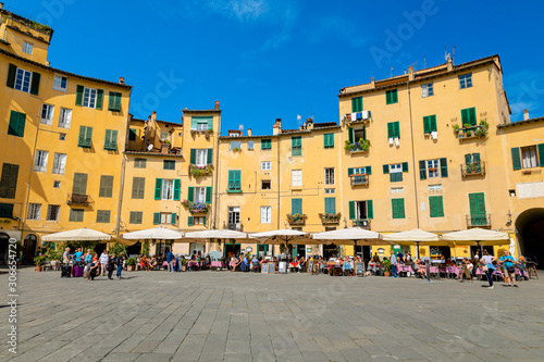 Lucca, Tuscany / Italy - October 10, 2019: View of Piazza dell'Anfiteatro, a famous elliptical square in the historic centre of Lucca, with one of the four arched gateway in a sunny autumn day © tetyanaustenko