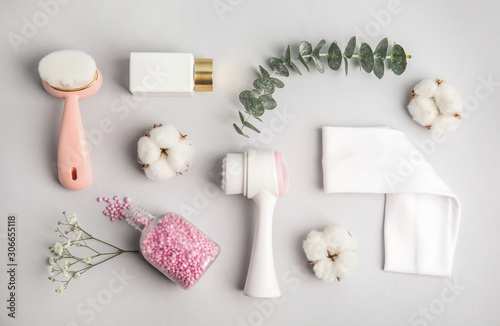 Flat lay composition with face cleansing brushes on light grey background. Cosmetic accessories