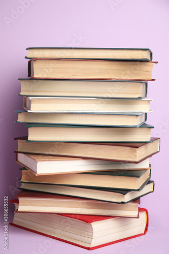 Stack of different hardcover books on violet background © New Africa