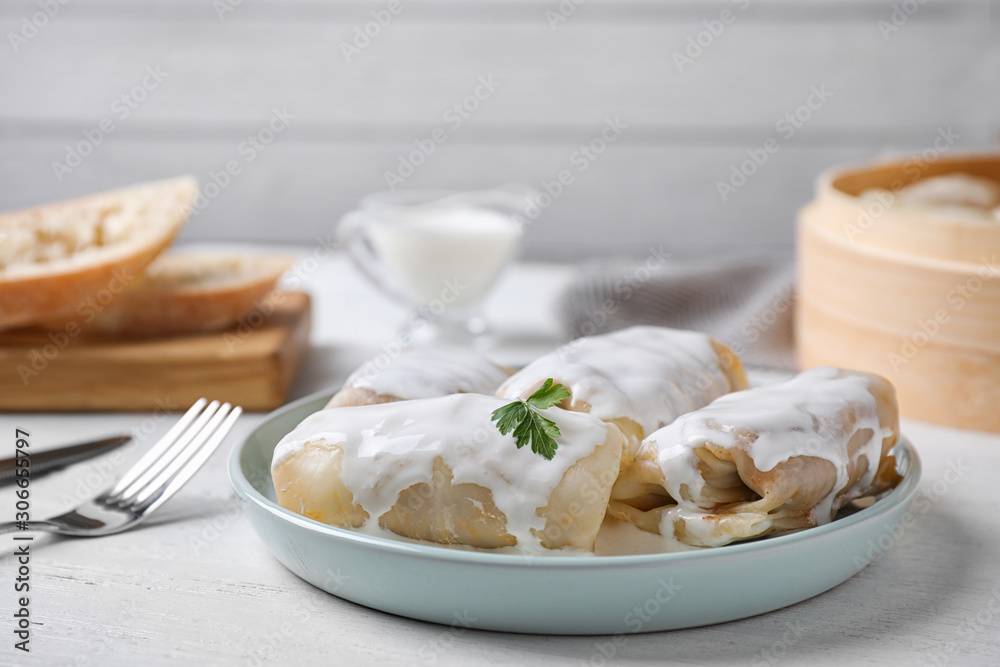 Delicious cabbage rolls served on white wooden table. Space for text