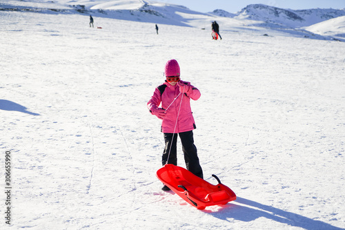 Little girl sledding at Sierra Nevada ski resort.