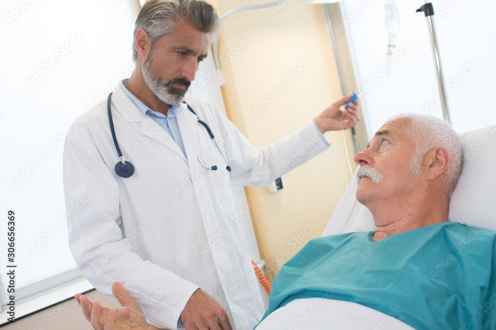 Fototapeta premium doctor in hospital room looking at patient