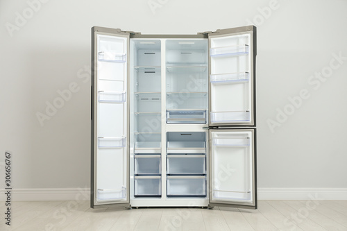Wallpaper Mural Modern empty refrigerator near light grey wall. Home appliance Torontodigital.ca