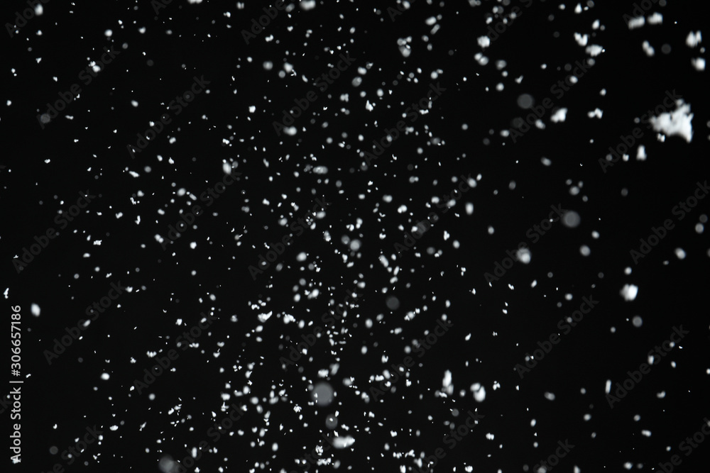 White snow falling down on black background