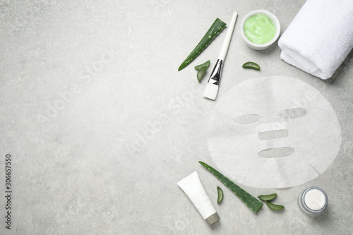 Flat lay composition with different cosmetic products and aloe on grey table, space for text