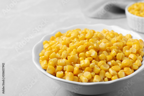 Delicious canned corn in bowl on marble table, closeup