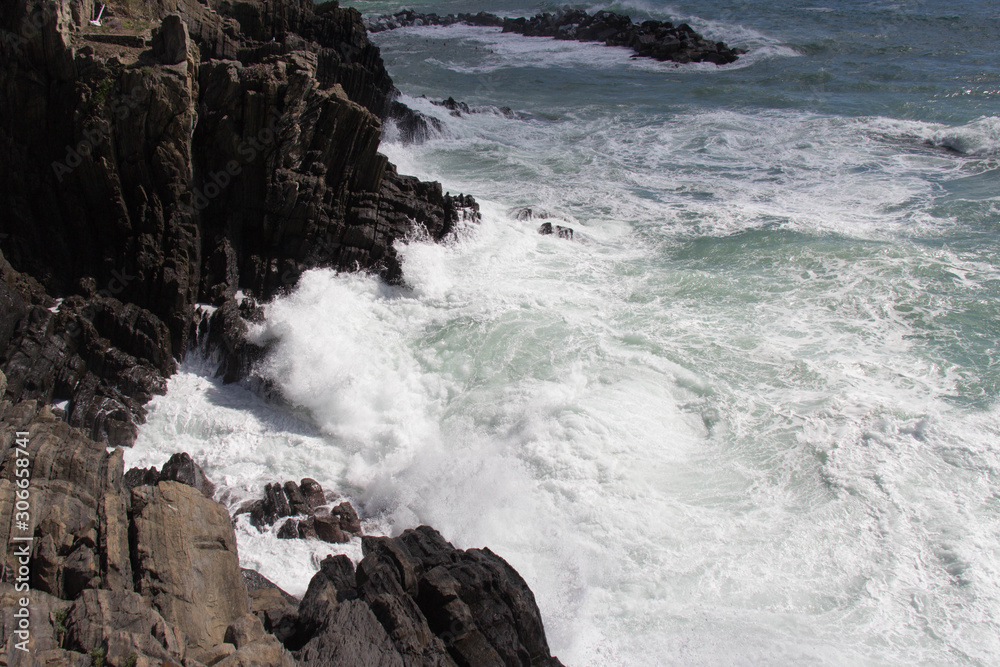 Wave are crashing on group of stones.