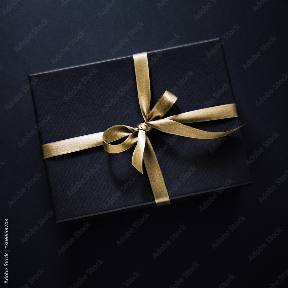 Gift wrapped in dark paper on dark background Gift wrapped in dark paper on dark background