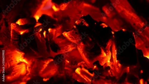 Red smouldering embers burnt in fire. Wind waving smoke. UHD
