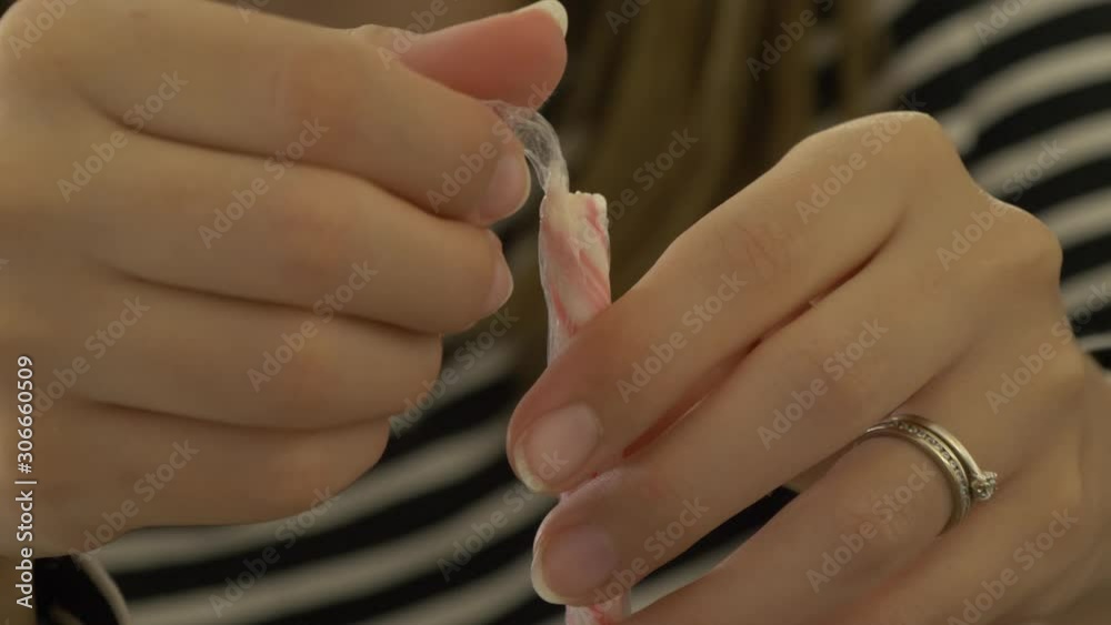 girl unwrapping a candy cane for christmas girl unwrapping a candy cane for christmas