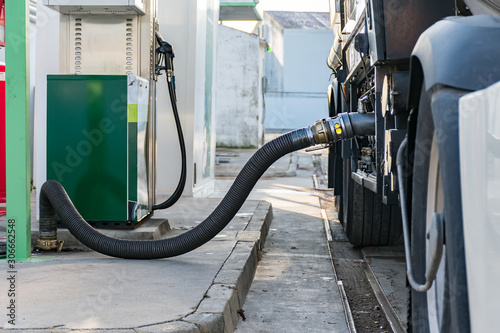 Camion cisterna de mercancias peligrosas suministrando combustible a una estacion de servicio