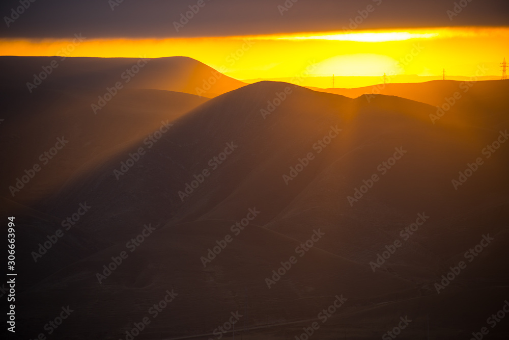 Cloudy weather. Zoom shot. Orange sunset view at mountains in Azerbaijan