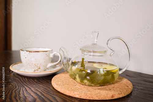 Glass teapot with ginger tea in a cozy coffee shop