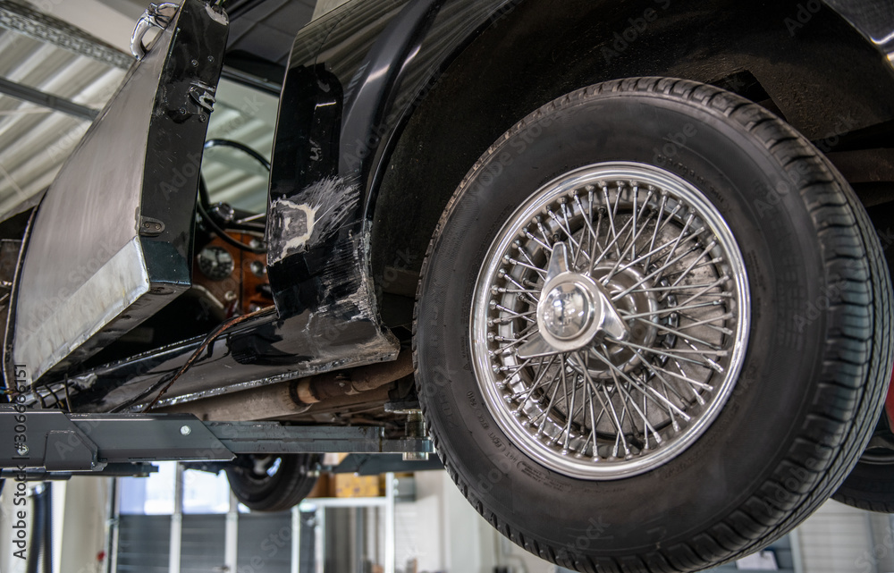 Oldtimer mit Speichenfelgen in der Werkstatt Oldtimer mit Speichenfelgen in der Werkstatt
