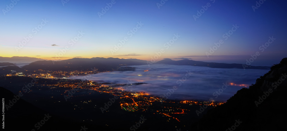 Blue Hour and fog over a city before the sunrise from the mountain