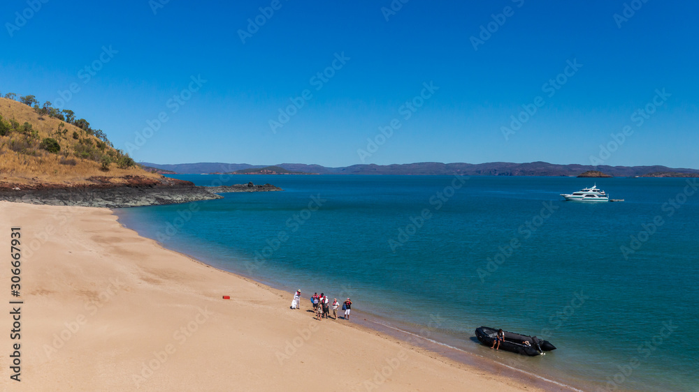 Tourists from a luxury expedition cruise ship  explore a remote beach on Naturalist Island in the Kimberley before a sightseeing flight over Prince Frederick Harbour.
