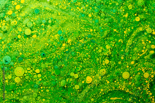 Abstract fluid background geometric circles and chlorophyll bubbles, green and yellow acrylic paints photo
