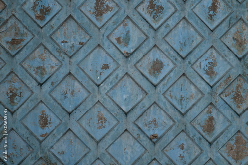 Texture of rhombus on the surface of a blue cement background with rust and smudges and scratches.