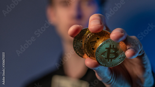 man holds cryptocurrency coin in his hands