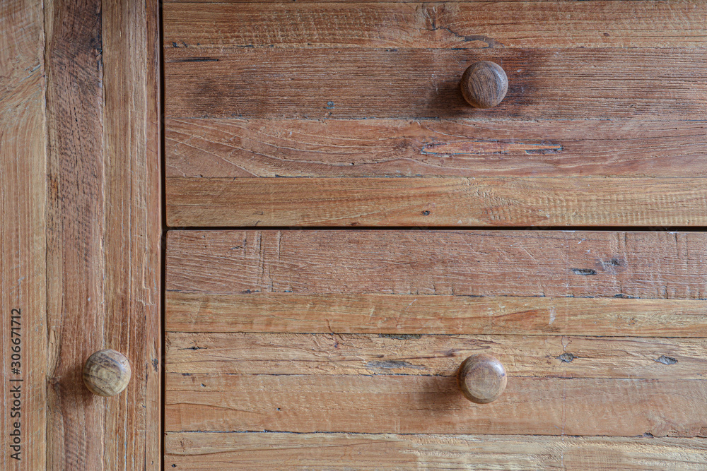 Hardwood furniture teak dresser with drawers and door with knobs in extreme closeup. Texture of rough wood visible. Hardwood furniture teak dresser with drawers and door with knobs in extreme closeup. Texture of rough wood visible.