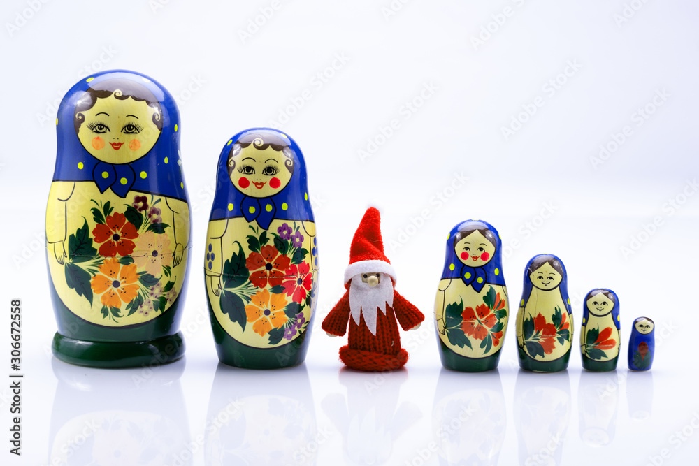 Weihnachtsmann zwischen einer Reihe russischer Matroschka-Puppen isoliert auf weißem Hintergrund