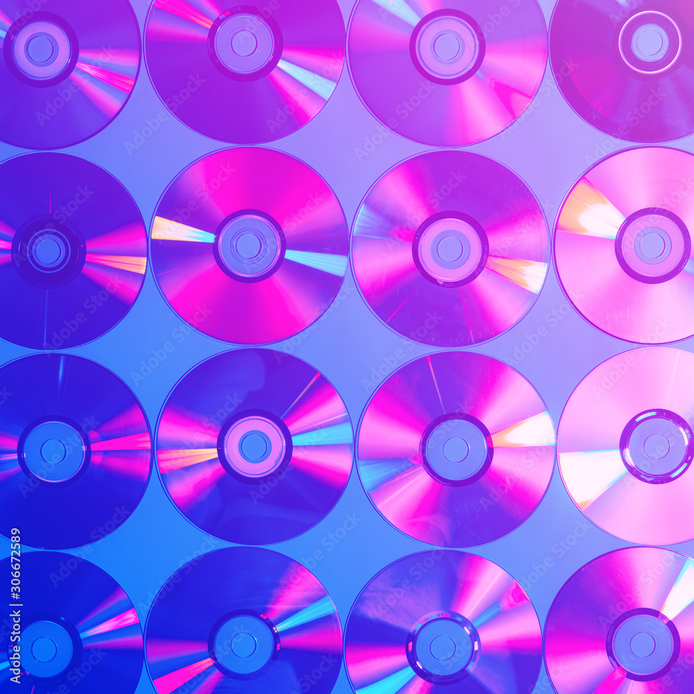 CDs on a plain background illuminated with neon light pink blue, minimal style CDs on a plain background illuminated with neon light pink blue, minimal style